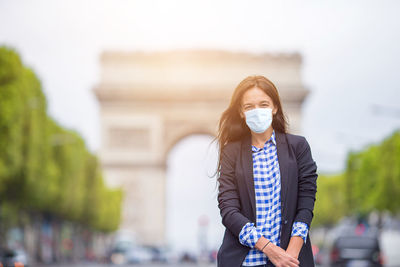 Portrait of beautiful woman standing against blurred background