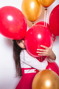 Rear view of girl holding balloons