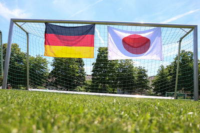 Red flags on soccer field against sky