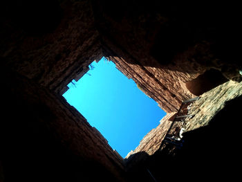 Low angle view of blue sky seen through hole