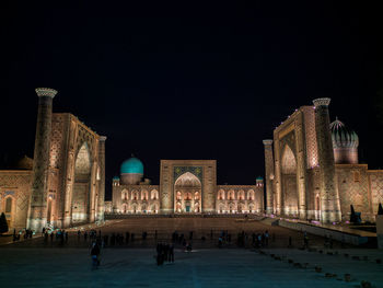 Group of people in front of historical building at night