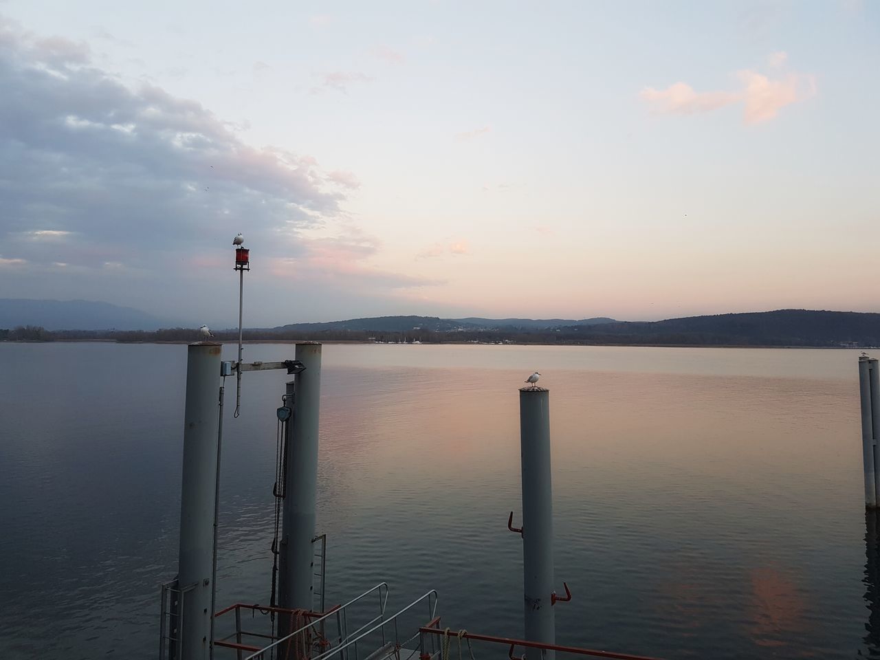 WOODEN POSTS IN SEA AGAINST SKY