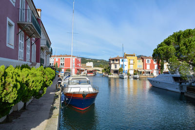 Boats moored at harbor against sky