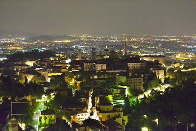 High angle view of illuminated cityscape against sky at night