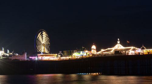 Illuminated ferris wheel in city at night