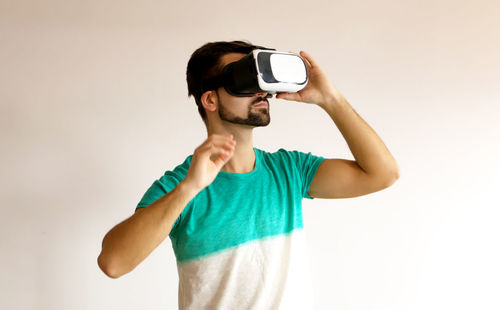 Young man using mobile phone against white background