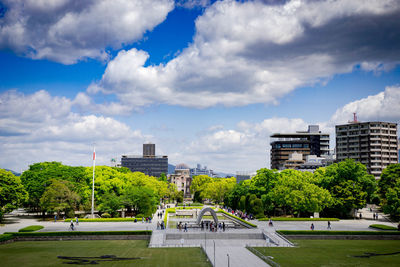 Road by buildings in city against sky