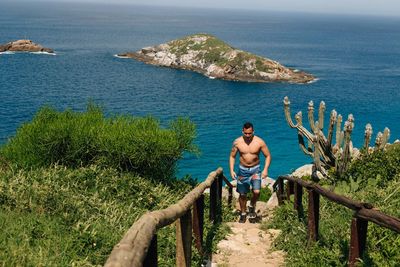 Rear view of shirtless man standing in sea