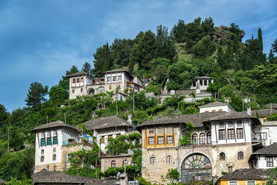 Low angle view of buildings and trees against sky