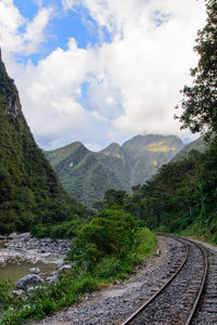 Railroad track amidst mountains against sky