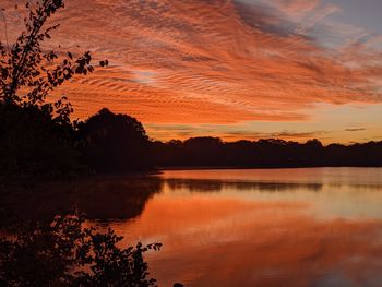 Scenic view of lake against orange sky