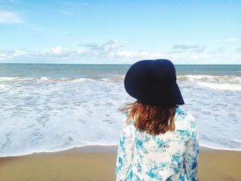 Rear view of woman standing on beach