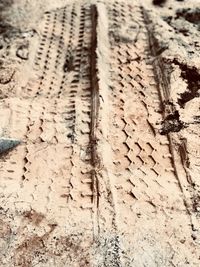 High angle view of tire tracks on sand