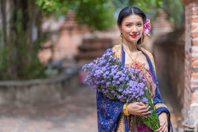 Portrait of smiling woman holding bouquet