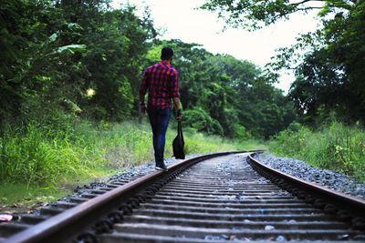 Rear view of man on railroad track
