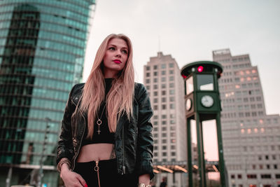 Young woman standing against skyscrapers