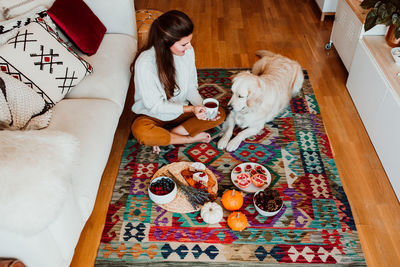 High angle view of woman with dog at home