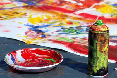 Close-up of multi colored paint in bowl on table