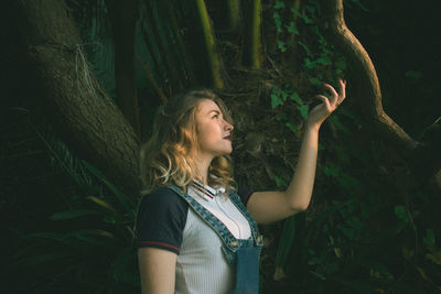 Young woman standing at forest