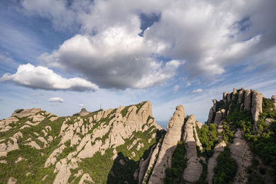 Low angle view of rocks on mountain against sky