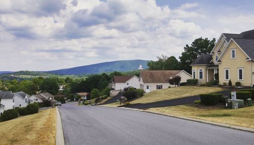 Houses in town against cloudy sky