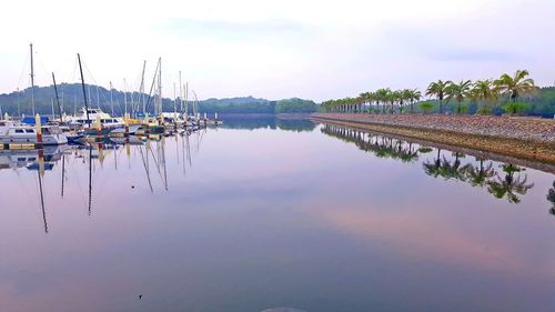 Sailboats moored in lake against sky