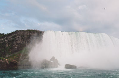 Scenic view of waterfall against sky