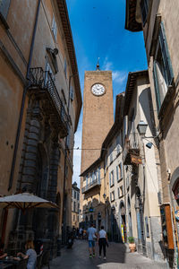 People walking on street amidst buildings in city