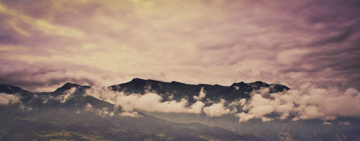 Scenic view of mountains against cloudy sky