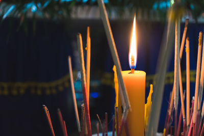 Close-up of illuminated candles with incense sticks