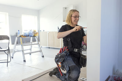 Female electrician renovating house