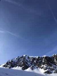 Snow covered mountain against blue sky