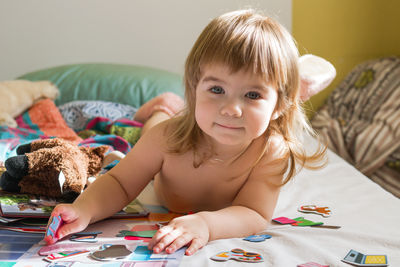 Portrait of cute girl with teddy bear at home