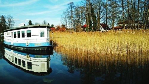 Reflection of boat in lake against sky