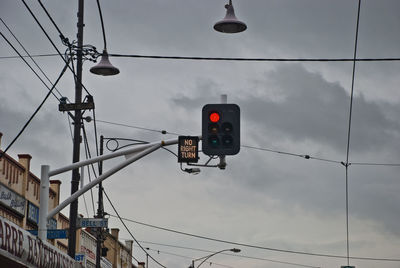 Low angle view of traffic signal against sky in city