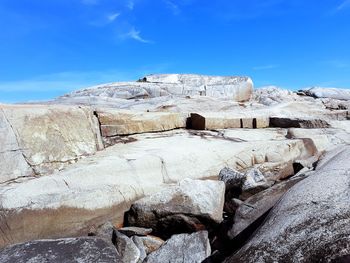 Rock formations on landscape against blue sky