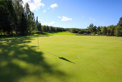 Scenic view of golf course against sky