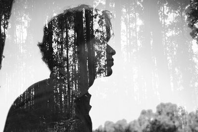 Multiple exposure of man and tree against sky