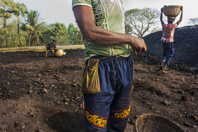 Low section of man standing on field