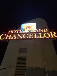 Low angle view of information sign at night