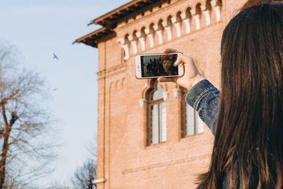 Portrait of woman photographing with mobile phone