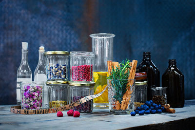 Various fruits in glass bottles on table