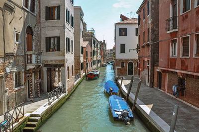 Canal overview with boats and buildings in the city center of venice, italy.