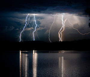 Reflection of lightning on lake at night