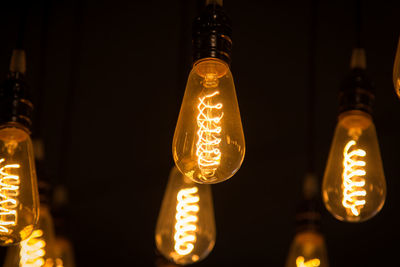 Low angle view of illuminated light bulbs