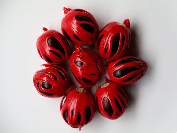 High angle view of red berries on white background