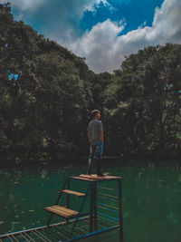 Man standing by lake against sky