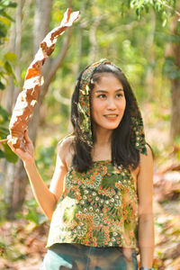 Portrait of a smiling young woman standing outdoors