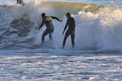 Men surfing in sea