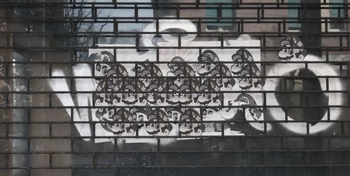 Low angle view of metal grate on wall